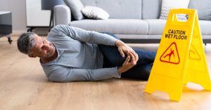 Man on floor holding his knee after slip and fall.